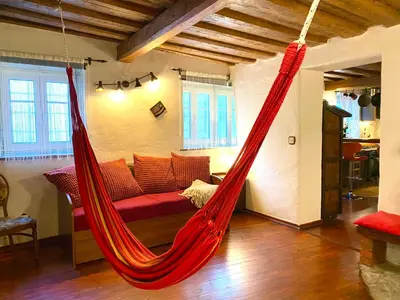 a red hammock in a living room with a couch at Under The Castle Apartments Ljubljana in Ljubljana