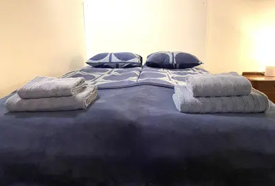 a large blue bed with two pillows on it at Under The Castle Apartments Ljubljana in Ljubljana