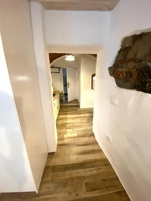 a hallway with white walls and wood flooring at Under The Castle Apartments Ljubljana in Ljubljana