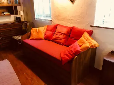 a couch with colorful pillows on it in a room at Under The Castle Apartments Ljubljana in Ljubljana