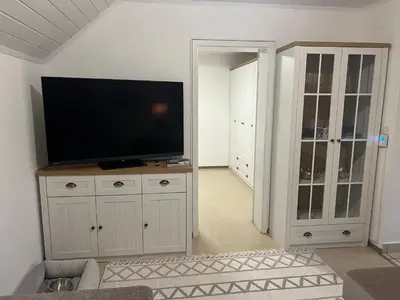 a living room with a flat screen tv on a cabinet at Bella Mura Nature Apartment Lipa 97 in Podčetrtek