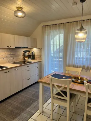a kitchen with a wooden table and chairs in a kitchen at Bella Mura Nature Apartment Lipa 97 in Podčetrtek