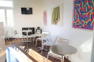 a room with tables and chairs and a tv at Budget dbl Studio free breakfast in Ljubljana