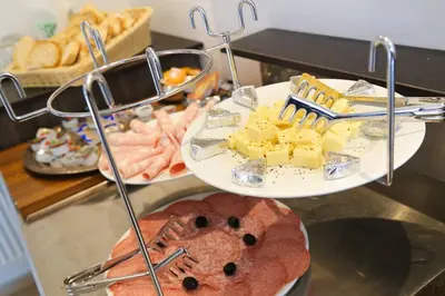 two plates of food on a buffet with cheese and bread at Budget dbl Studio free breakfast in Ljubljana