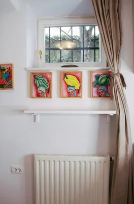 a window with four pictures on a shelf next to a radiator at Budget dbl Studio free breakfast in Ljubljana
