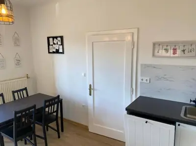 a kitchen with a table and chairs and a door at Apartment Herberstainova in Ljubljana