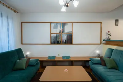 a living room with two green couches and a table at Apartment Maj, Kranjska Gora - Center in Kranjska Gora