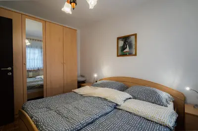 a bedroom with a bed with blue sheets and a mirror at Apartment Maj, Kranjska Gora - Center in Kranjska Gora