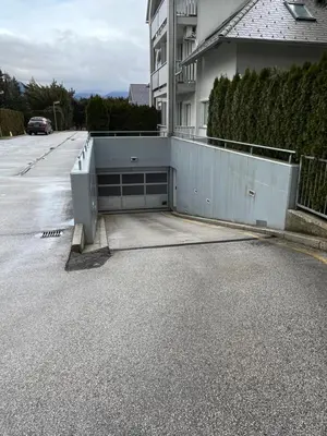 a garage in a parking lot next to a house at Bled lux apartment in Bled