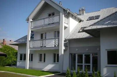 a white house with a balcony on it at Bled lux apartment in Bled