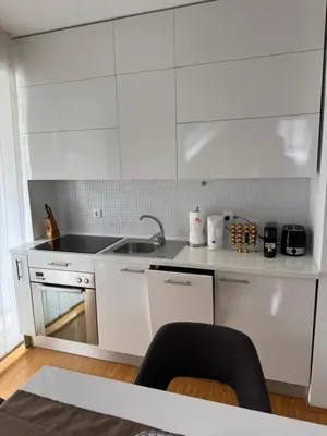 a white kitchen with white cabinets and a sink at Bled lux apartment in Bled