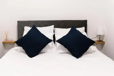a bed with black and white pillows on it at Oliver street apartment Vipava - 50m from city center in Vipava