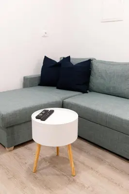 a living room with a couch and a white coffee table at Oliver street apartment Vipava - 50m from city center in Vipava