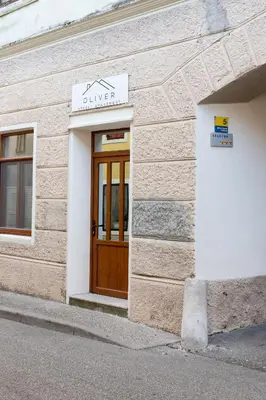 a building with a wooden door on the side of it at Oliver street apartment Vipava - 50m from city center in Vipava