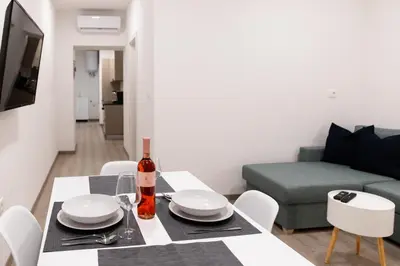 a living room with a table with a bottle of wine at Oliver street apartment Vipava - 50m from city center in Vipava