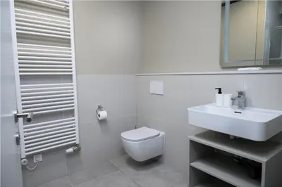 a white bathroom with a toilet and a sink at Primus apartments in Ljubljana