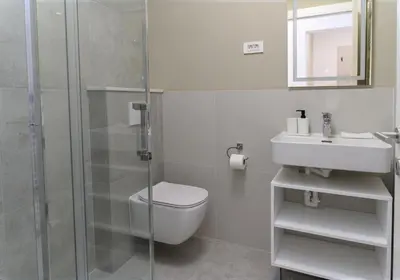 a bathroom with a shower and a toilet and a sink at Primus apartments in Ljubljana