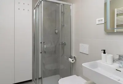 a bathroom with a shower and a toilet and a sink at Primus apartments in Ljubljana