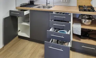 a kitchen with blue drawers and a sink at HIŠKA TIBAUT 122 vključene kopalne karte in Veržej