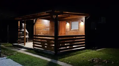 a small wooden cabin with a window and lights on it at HIŠKA TIBAUT 122 vključene kopalne karte in Veržej