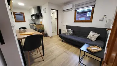 a living room with a couch and a table at HIŠKA TIBAUT 122 vključene kopalne karte in Veržej