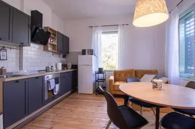 a kitchen and dining room with a table and chairs at Garden apartment No.3 in Bled
