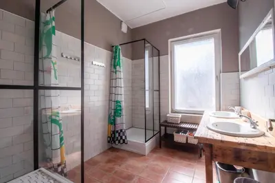 a bathroom with two sinks and a shower at Garden apartment No.3 in Bled