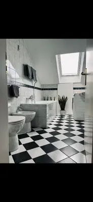 a bathroom with two toilets and a checkered floor at JZ Loft Ljubljana with Parking and Self Check in in Ljubljana