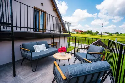 a balcony with two chairs and a table with flowers at Pri stari mami in Tomaž pri Ormožu
