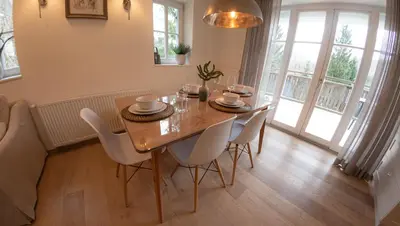 a dining room with a wooden table and chairs at Creek House Bohinj in Bohinj