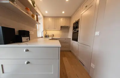 a kitchen with white cabinets and a white counter top at Creek House Bohinj in Bohinj