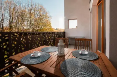 a wooden table with two cups and saucers on a balcony at Green Valley Apartments in Zavrč
