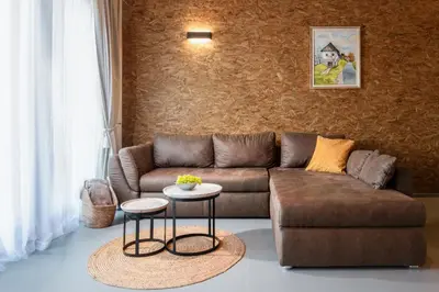 a living room with a brown couch and a table at Green Valley Apartments in Zavrč
