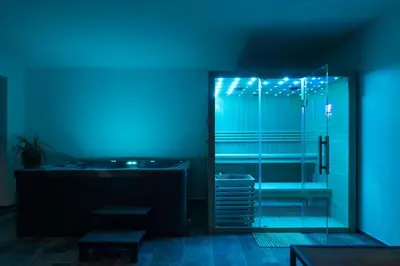 a bathroom with a glass shower with blue lights at Green Valley Apartments in Zavrč