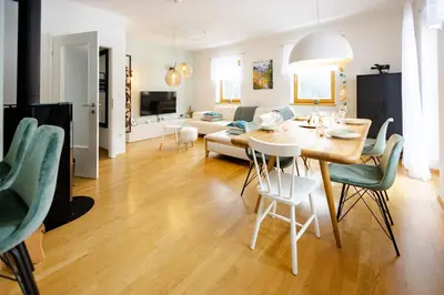 a dining room and living room with a table and chairs at Waterfall Apartment - Cozy Mountain Retreat in Kranjska Gora