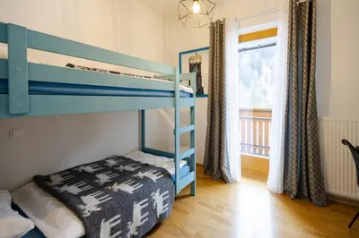 a bedroom with two bunk beds and a window at Waterfall Apartment - Cozy Mountain Retreat in Kranjska Gora