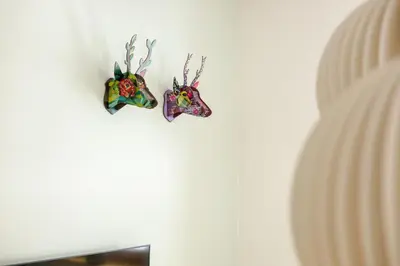 two ornaments are hanging on a white wall at Waterfall Apartment - Cozy Mountain Retreat in Kranjska Gora