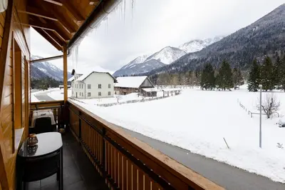 a balcony with a view of a snow covered field at Waterfall Apartment - Cozy Mountain Retreat in Kranjska Gora