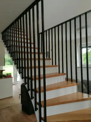 a staircase with wood and black railings in a house at Hiša Štolc in Gornja Radgona