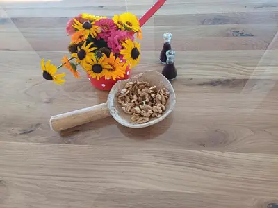a table with a bowl of nuts and a vase of flowers at Hiša Štolc in Gornja Radgona