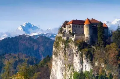 a castle on the side of a mountain at Bela Luna - Charming Garden Cottage near Lake Bled in Bohinjska Bela