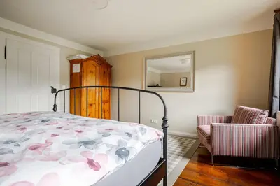 a bedroom with a bed and a mirror and a chair at Bela Luna - Charming Garden Cottage near Lake Bled in Bohinjska Bela