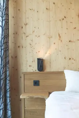 a bedroom with a bed and a wooden wall at Glamping house Julija - Wellness & View in Ivanjkovci