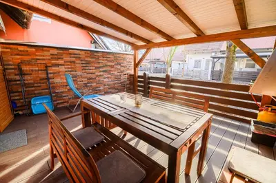 a table and chairs on a porch with a brick wall at Holiday Home Oxi in Čatež ob Savi
