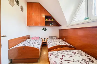 two beds in a small room with a window at Holiday Home Oxi in Čatež ob Savi