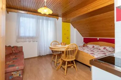 a bedroom with a bed and a table and chairs at Apartments and Rooms Hodnik Slavko in Bohinj