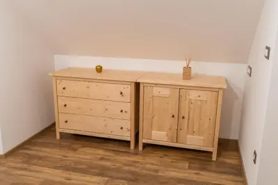 a wooden dresser in a corner of a room at Apartments and Rooms Hodnik Slavko in Bohinj