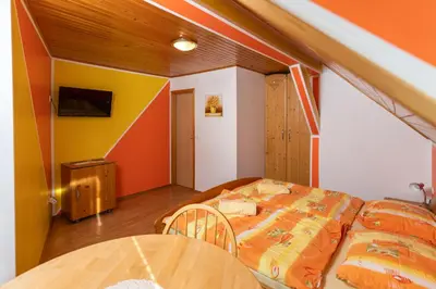 a bedroom with a bed and a table at Apartments and Rooms Hodnik Slavko in Bohinj