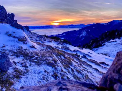 a view of a snowy mountain with the sunset in the background at Apartment Mandy in Rečica ob Savinji