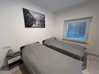 a bedroom with two beds and a window at Apartment Mandy in Rečica ob Savinji